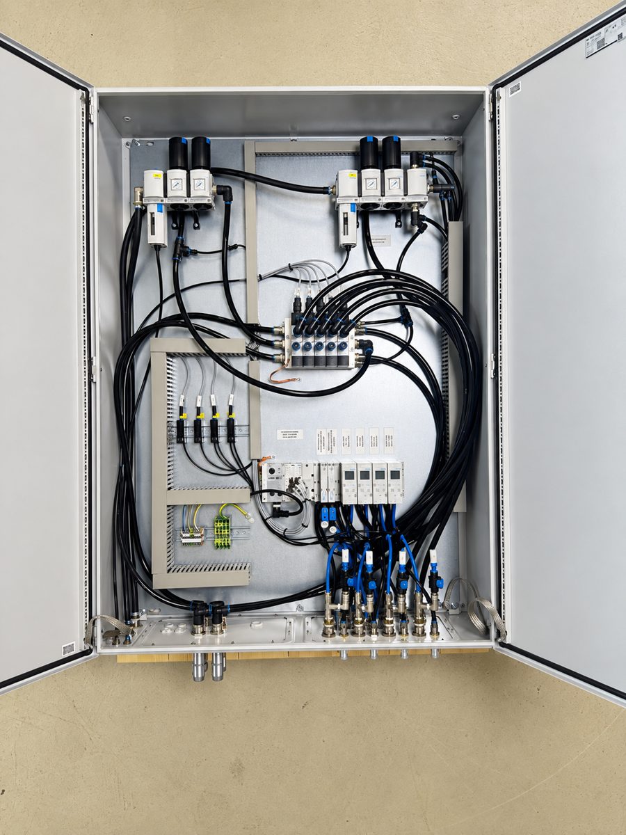 Geöffneter Schaltschrank mit Ventilinsel, Klemmen und Steckverbindungen